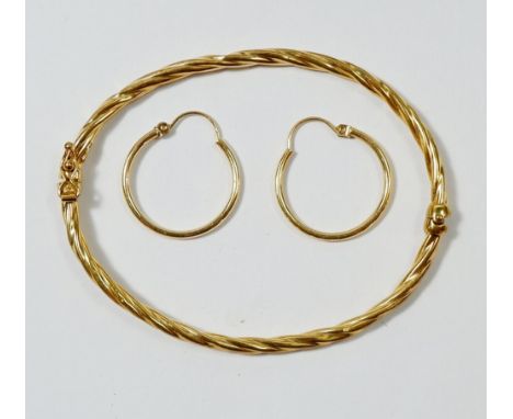 A 9 carat gold hinged bangle, 3g and a pair of gold hoops marked 14k, 1.1g 