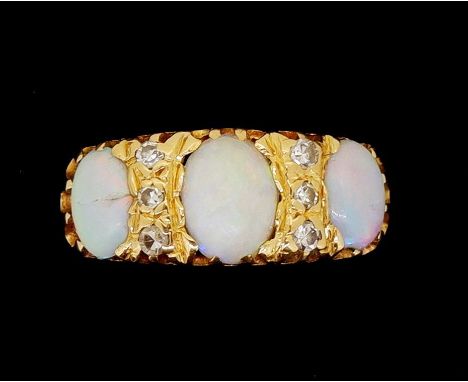 An 18 carat gold three stone opal ring with three oval cut opals and six diamonds, one opal cracked and one chipped, size M 