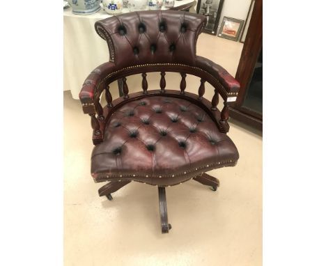 A leather button back swivel captain's chair