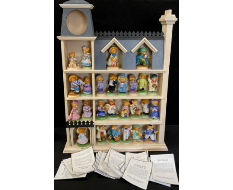 Franklin mint bear figure collection, housed in a wall mounted display shelf, as a four storey town house.