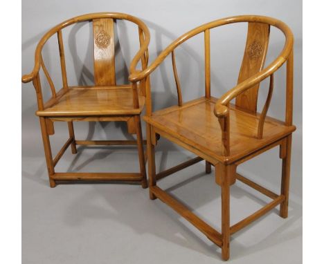 A pair of Chinese polished hardwood moon back chairs, each with shaped rails, scroll arms and vertical splats set with a shap