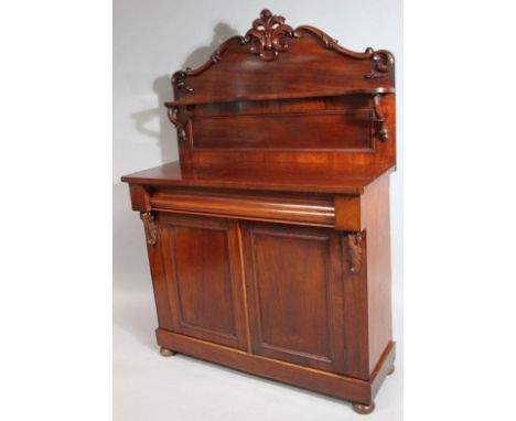 A Victorian mahogany chiffonier, of good proportion, with upper serpentine shelf and centred by carved pierced scrolls and fl