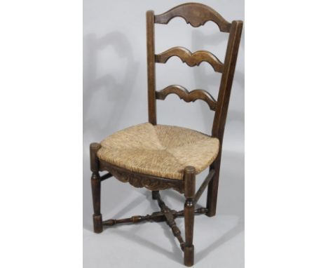 An early 20thC rush seated ladder back chair, with shaped splat, cylindrical supports, joined by a low X stretcher, 85cm high