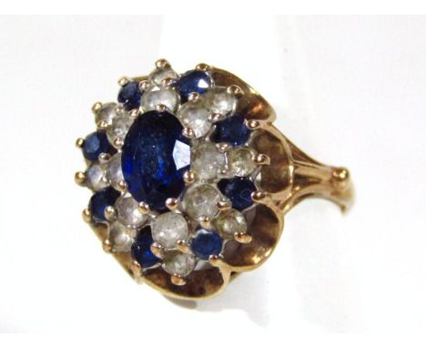 A ladies fancy dress ring, florally claw set with blue and white stones, on a basket weave part pierced shank, unmarked yello