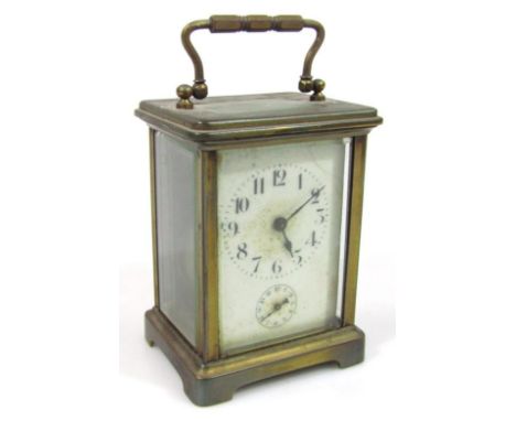 A late 19th/early 20thC brass carriage clock, of square outline, the 5cm dia. dial on a plate back, in a four part glazed cas