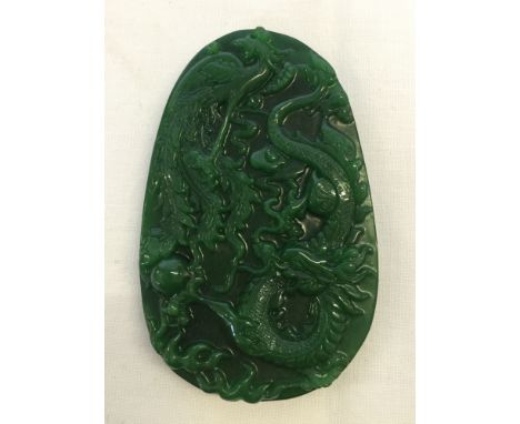 A large carved Jade pendant with dragon & peacock design (approx 6cm wide x 9½cm high).
