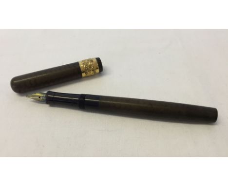 A Mabie Todd 'Swan' fountain pen in brown wave design with ornate gold coloured metal collar.