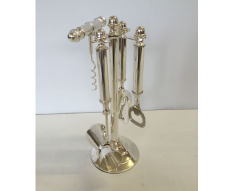 A silver plated stand with 4 bar tools.