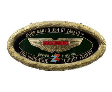 Two Aston Martin themed garage display emblems,modern, the first a hand-painted commemorative oval with fibreglass raised lau