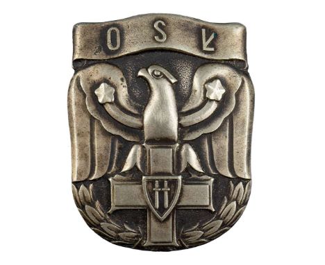 One-piece badge made of white metal, oxidized. A badge in the shape of a shield with a stylized eagle leaning its talons on t