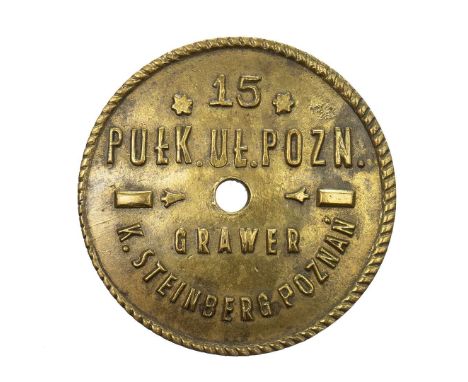 A cap dedicated to the badge of the 15th Poznań Uhlan Regiment. The cap is minted in brass, with an inscription visible on th
