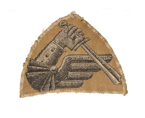 Triangular patch in the form of an armored arm holding a sword, the emblem of the 2nd Warsaw Armored Division, a unit of the 