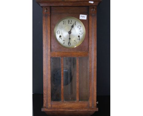 A wooden cased chiming wall clock. 