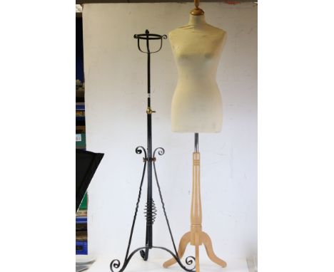 A dress maker mannequin together with a wrought iron lamp base. 