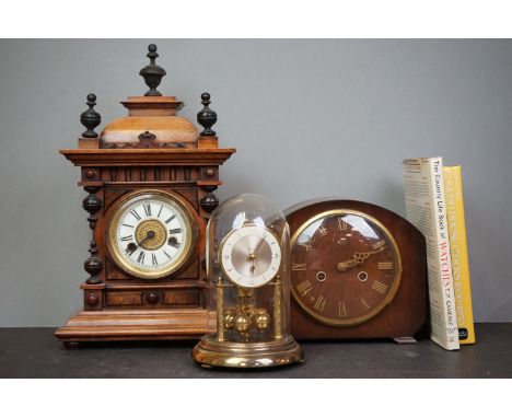 An ornate wooden clock, a mantle clock, and an anniversary clock together with two clock books.
