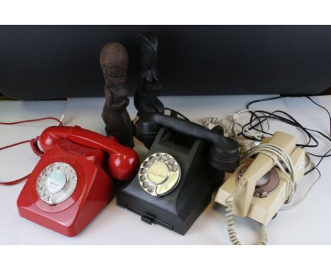 A collection of three vintage BT Telephones together with two tribal wood carvings. 