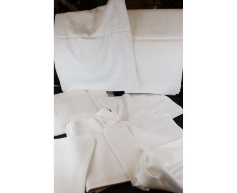 A collection of vintage white linen table cloths. 