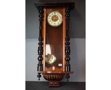 A wooden and glass cased wall clock with brass pendulum. 