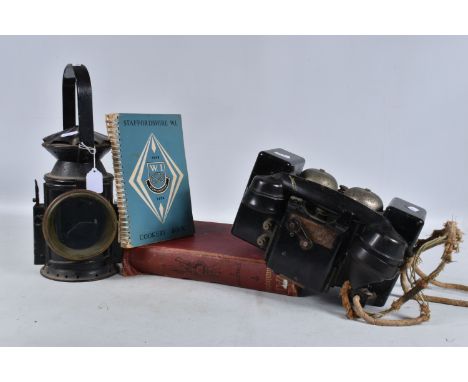 A MILITARY RAILWAY LAMP, field telephone and two books, the lamp is a standard railway one but has a broad arrow marking on t