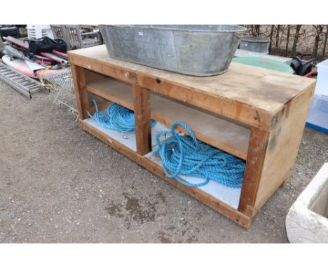 A large wooden plant potting bench fitted two shelves beneath 
