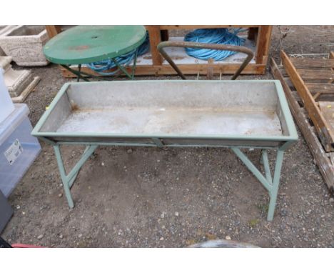 A galvanised trough on painted metal stand