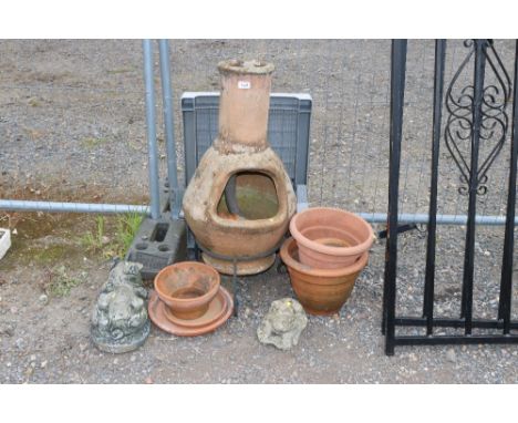 A terracotta chimney on stand; quantity of terracotta plant pots and two concrete garden ornaments and a plastic table  