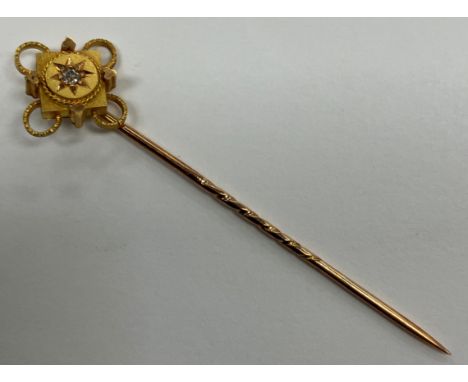 A yellow metal diamond set tie pin, 6 cm long, 2 g