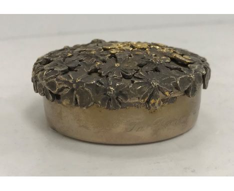 A Stuart Devlin silver and silver gilt circular trinket box, the lid with applied pierced cast flower head decoration on a pl