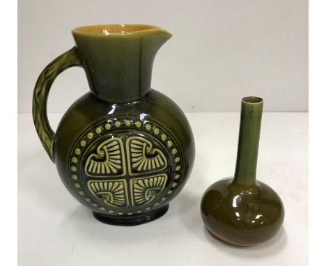 A Linthorpe pottery jug in the style of Christopher Dresser green glazed with Aztec motif medallions and naturalistic branch 