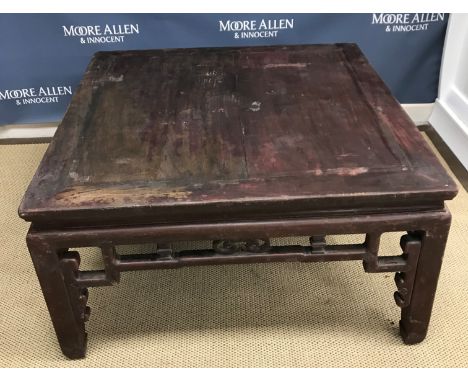 A circa 1900 Chinese hardwood low table, the plank top above a fretwork carved frieze on square supports to scroll feet 94 cm