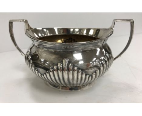 A Victorian silver sugar basin of oval form with reeded decoration and side handles, raised on an oval foot (by Robert Harper