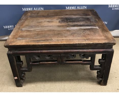 A circa 1900 Chinese hardwood low table, the plank top above a fretwork carved frieze on square supports to scroll feet 95 cm