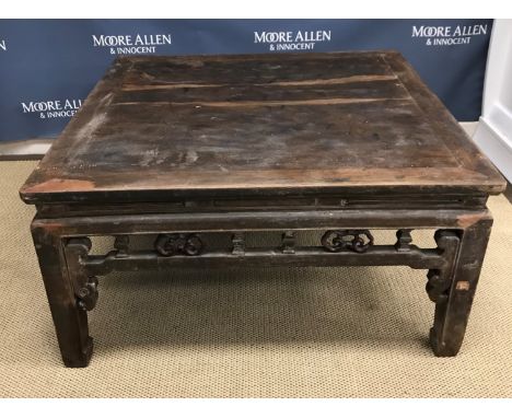 A circa 1900 Chinese hardwood low table, the plank top above a fretwork carved frieze on square supports to scroll feet 98.5 