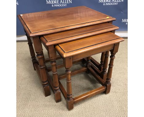 A modern cherry wood nest of three occasional tables by Simpson of Norfolk, the tops with moulded edge on turned and ringed l