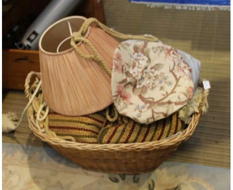 A DECORATIVE OVAL BASKET CONTAINING INTERIOR FURNISHING ITEMS, cushions, tie-backs, light shade, etc. 