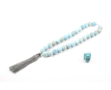 A string of blue stone 'monk's beads' and a netsuke. The necklace comprising 30 large beads of circa 2.8cm diameter with knot