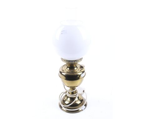 A converted brass oil lamp. With glass chimney and white globe shade. H51cm