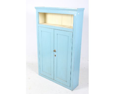 A vintage pine cupboard. Painted blue and cream, with a single shelf over a pair of panelled doors, with brass handles, H156.