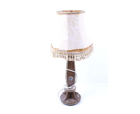 A 1930s electric table lamp. Decorated with metal plaques, mounted on a circular base, H43cm