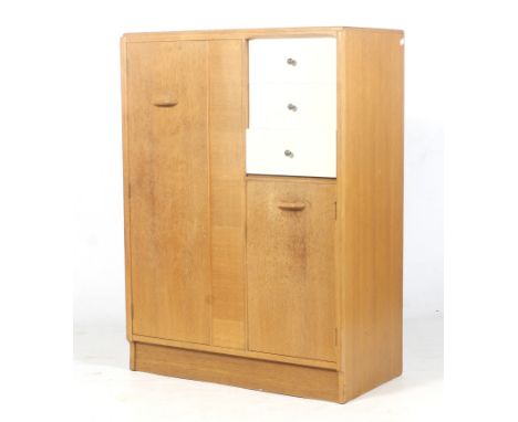 A mid-century E Gomme G-Plan (EG gold stamp) oak tall boy wardrobe. Single door wardrobe to the left, flanked by three white 