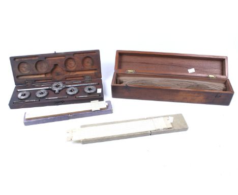 An assortment of vintage measuring tools. Comprising a draughtsman's French curves, a tap and die set and two slide rules