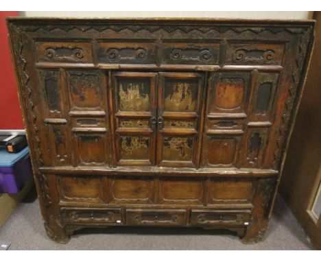 An Indian style vintage wood cabinet. The small central double doors opening to reveal a single shelf, over three small drawe