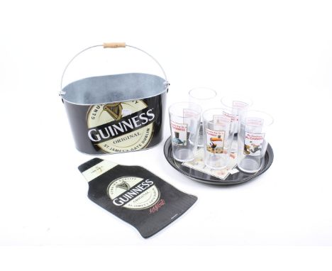 An assortment of vintage Guinness collectables. Including a pelican circular tray, a set of five pint glasses, a wall plaque 