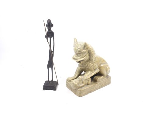 A ceramic Dog of Fo and a cast metal tribal figure. The Dog of Fo in a seated position and in a green glaze, H22cm, the figur