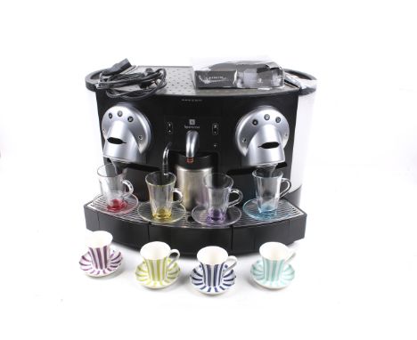 A Nespresso Gemini CS 220 Pro coffee machine. With a set of four colourful glass teacups and saucers and a set of four cerami