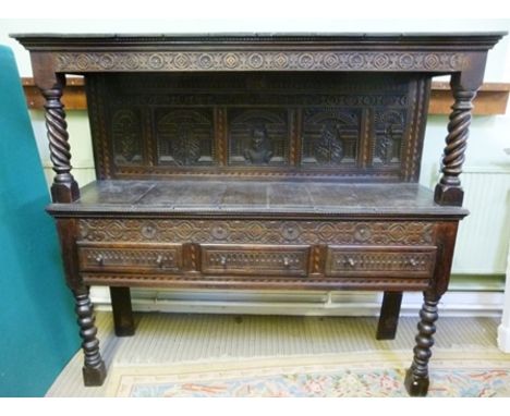 A PART 18TH CENTURY JACOBEAN STYLE OAK BUFFET having plank top over a floral blind fret carved frieze, the back panel carved 