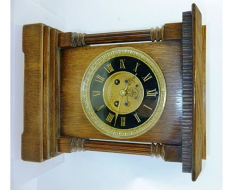AN OAK CASED MANTEL CLOCK having ebonised chapter ring with Roman numerals, 32cm high (12cm dial) 