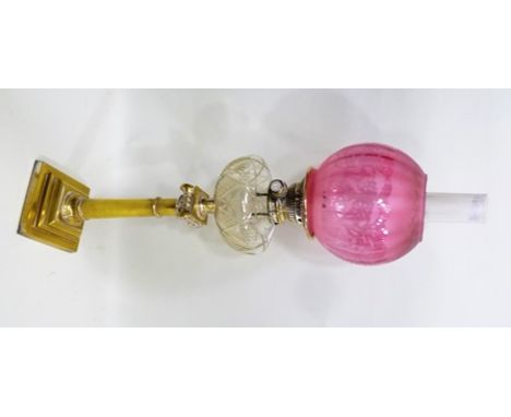 A LATE VICTORIAN OIL LAMP ionic column design with cut clear glass reservoir, a chimney and pink glass shade, overall stands 