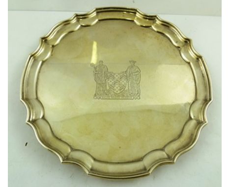 JOSEPH GLOSTER LTD. A CHIPPENDALE STYLE SILVER SALVER, having pie crust rim, bears two figure crest to centre "Salve Magna Pa