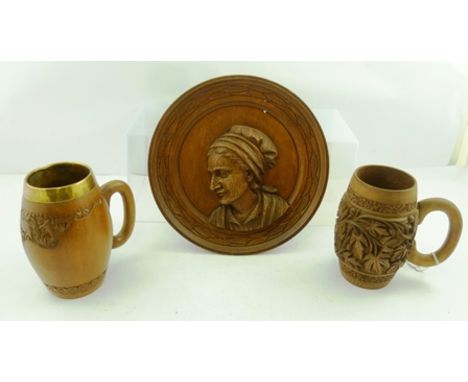 A COPPER BANDED COOPERED CIDER JUG, 24cm high with two Eastern carved WOOD TANKARDS, one brass lined and a carved oak ROUNDEL